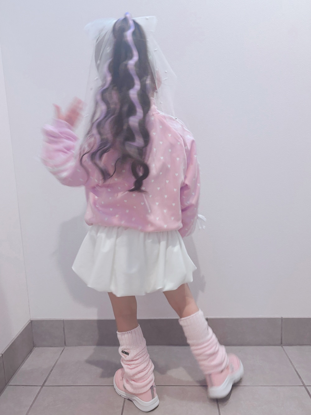 ピンク系のスニーカー、ピンク系のセットアップ、ホワイト系のスカートを着用したキッズの春コーディネートの4枚目の写真