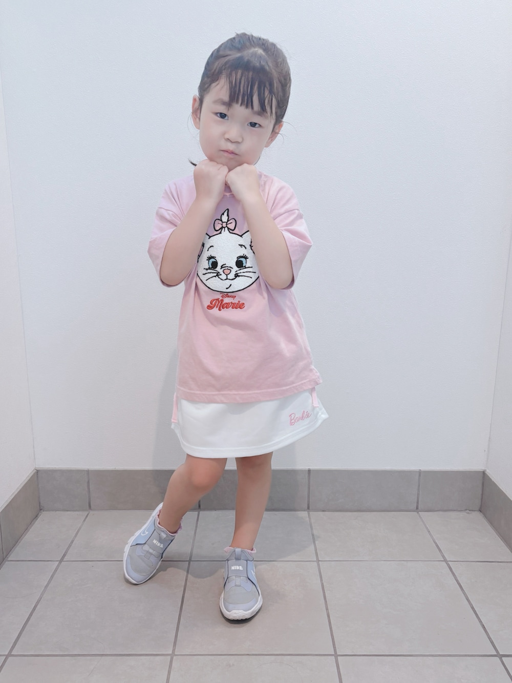 ブルー系のスニーカー、ピンク系のトップス、ホワイト系のスカートを着用したキッズの秋コーディネートの3枚目の写真