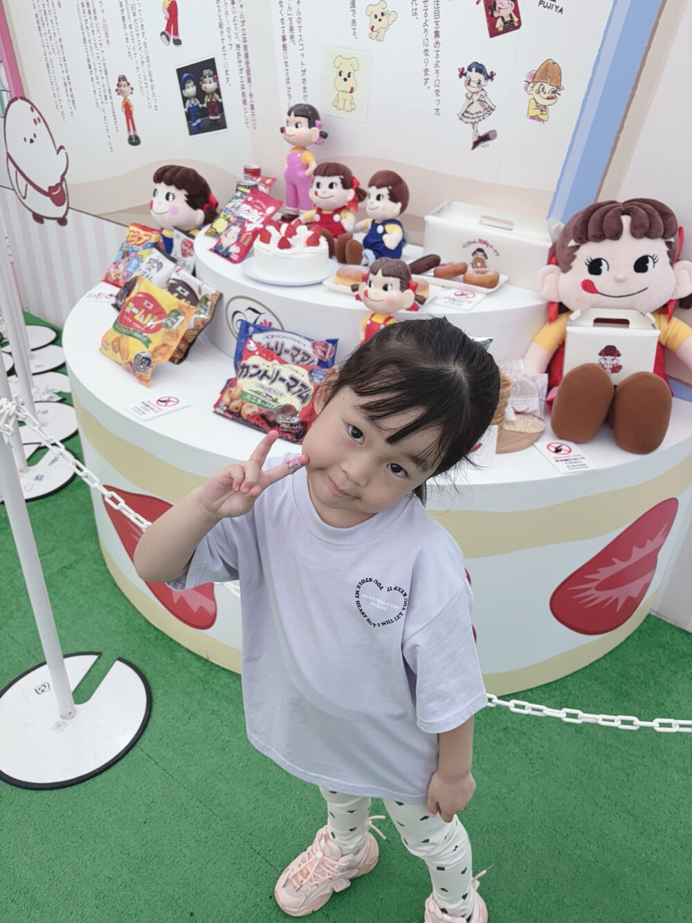 パープル系のトップス、ベージュ系のパンツ、ピンク系のスニーカーを着用したキッズの夏コーディネートの2枚目の写真