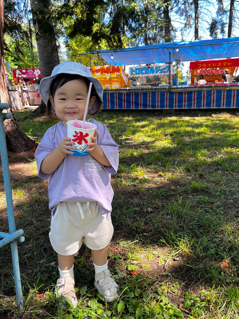 パープル系のTシャツ/カットソー、ベージュ系のパンツ、ベージュ系のサンダルを着用したキッズの夏コーディネートの2枚目の写真