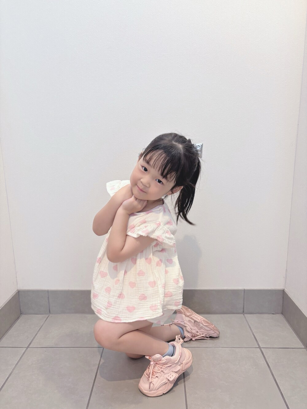 ホワイト系のトップス、ホワイト系のパンツ、ピンク系のスニーカーを着用したキッズの夏コーディネートの2枚目の写真