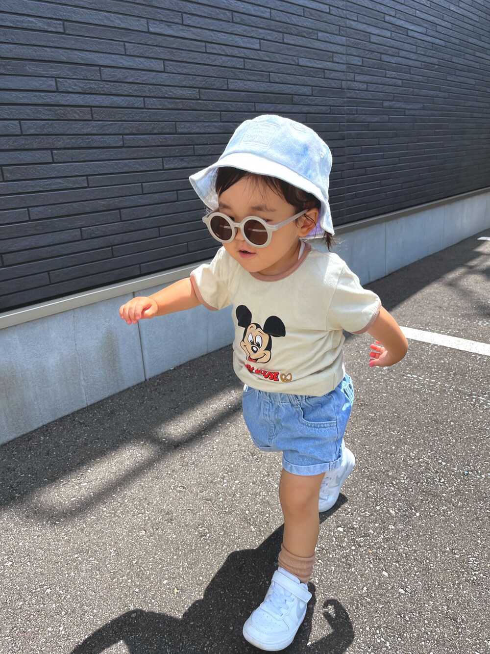 ベージュ系のTシャツ/カットソー、ブルー系のデニムパンツ、ホワイト系のスニーカーを着用したキッズの夏コーディネートの4枚目の写真