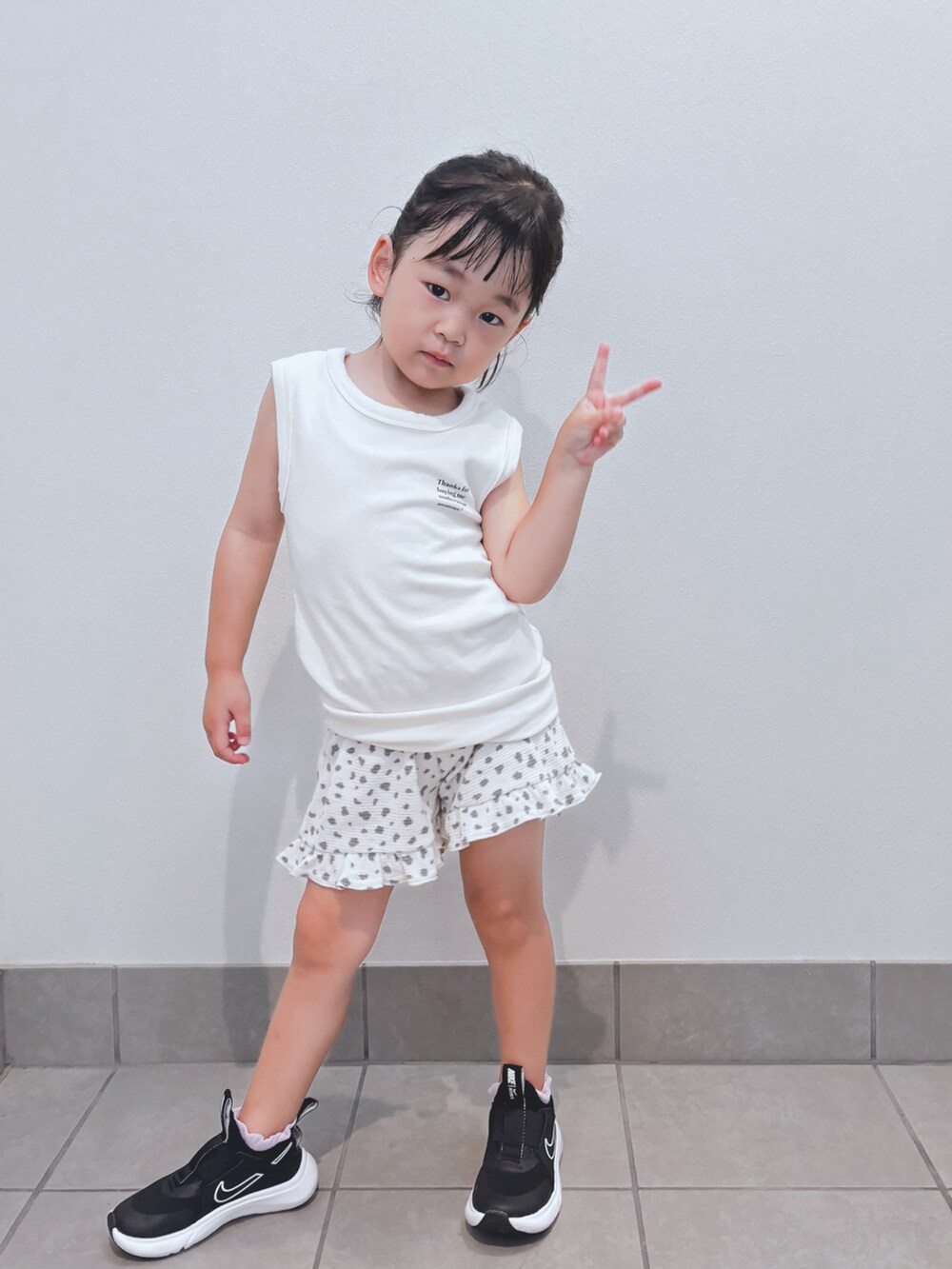 ホワイト系のトップス、ホワイト系のパンツ、ブラック系のスニーカーを着用したキッズの秋コーディネートの4枚目の写真