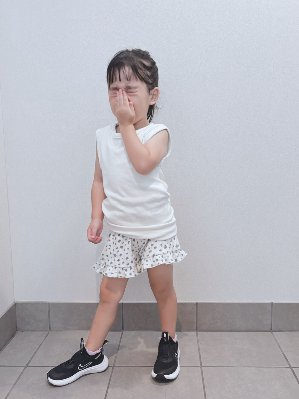 ホワイト系のトップス、ホワイト系のパンツ、ブラック系のスニーカーを着用したキッズの秋コーディネートの5枚目の写真