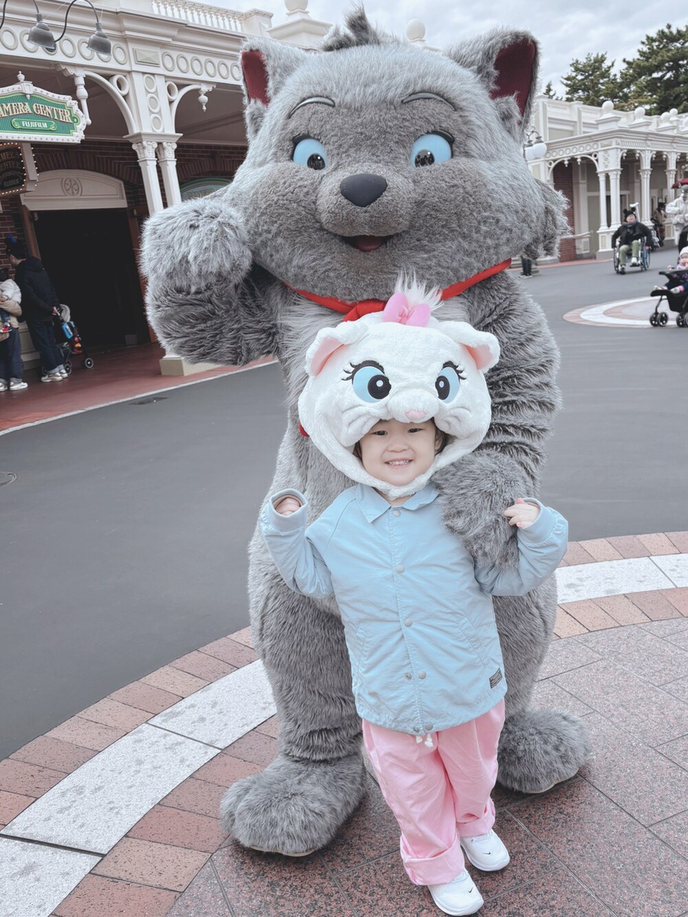 ブルー系のテーラードジャケット、ピンク系のオールインワン・サロペット、ホワイト系のスニーカーを着用したキッズの春コーディネートの2枚目の写真