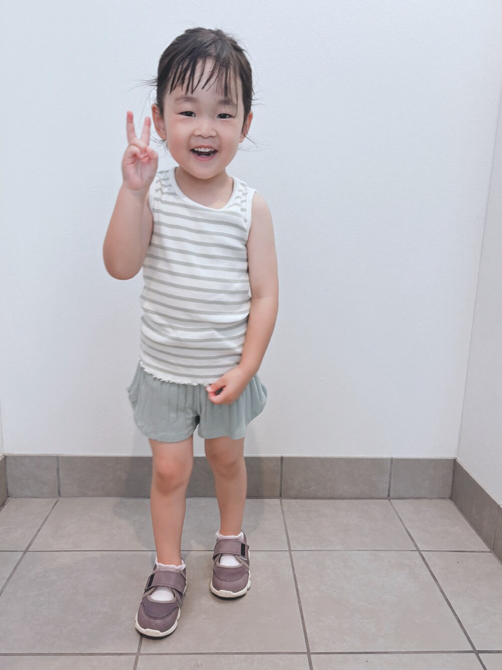 グリーン系のタンクトップ、グリーン系のパンツを着用したキッズの夏コーディネートの2枚目の写真
