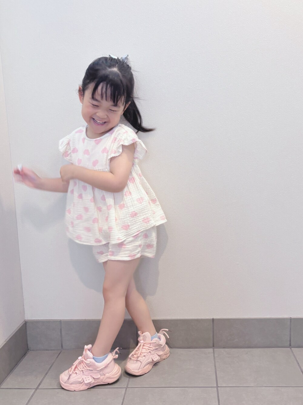 ホワイト系のトップス、ホワイト系のパンツ、ピンク系のスニーカーを着用したキッズの夏コーディネートの5枚目の写真