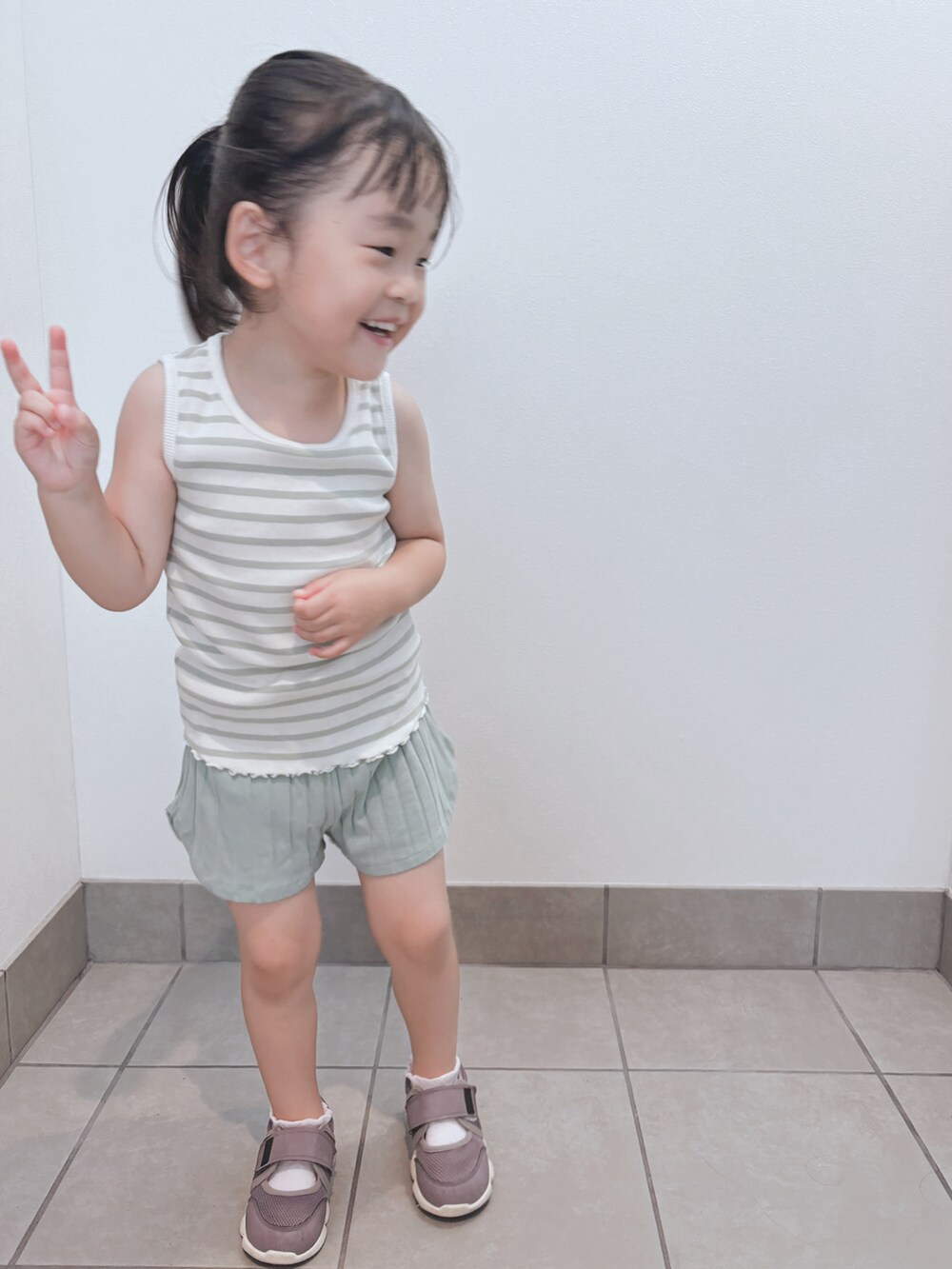 グリーン系のタンクトップ、グリーン系のパンツを着用したキッズの夏コーディネートの3枚目の写真