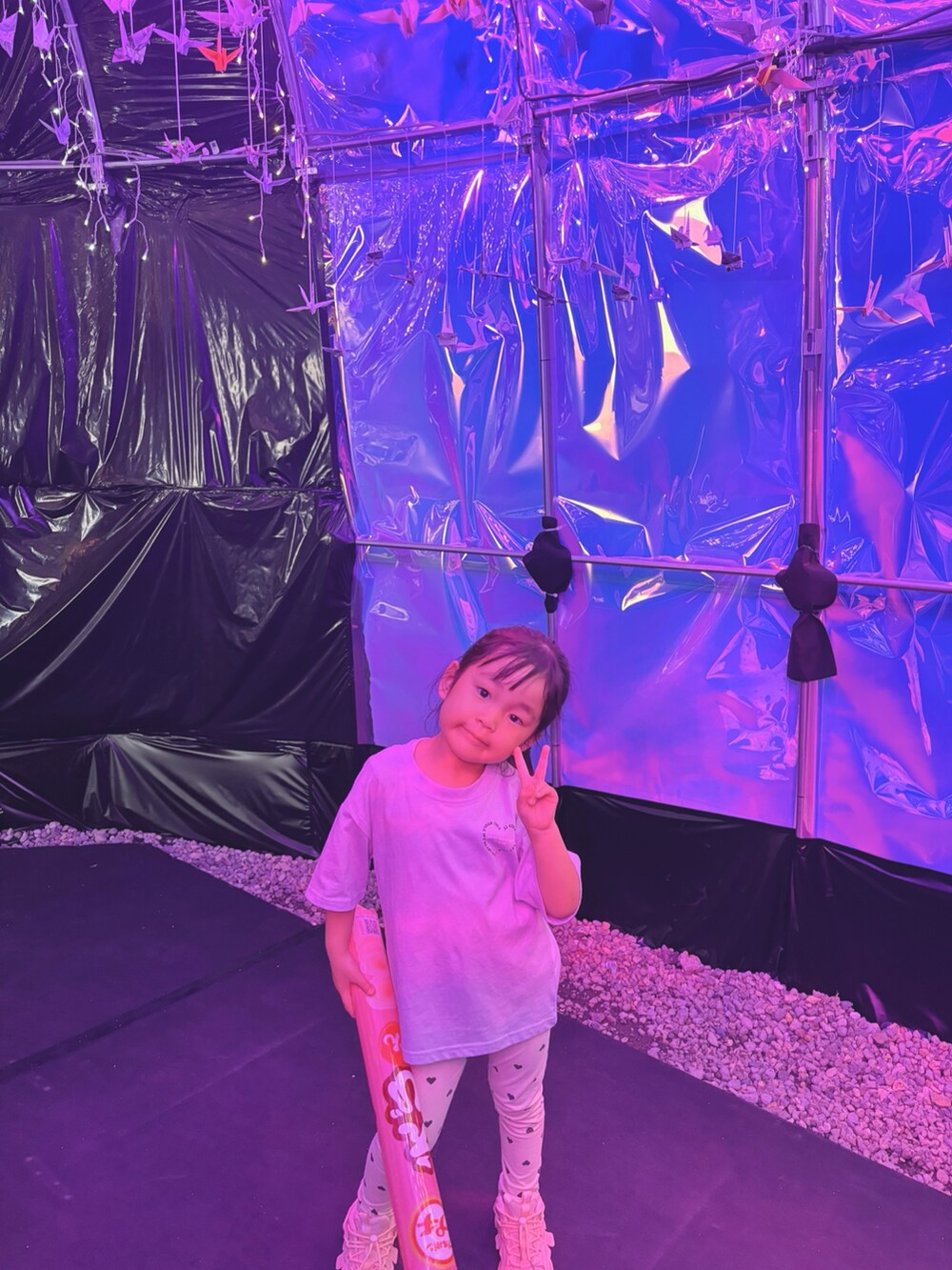 パープル系のトップス、ベージュ系のパンツ、ピンク系のスニーカーを着用したキッズの夏コーディネートの5枚目の写真