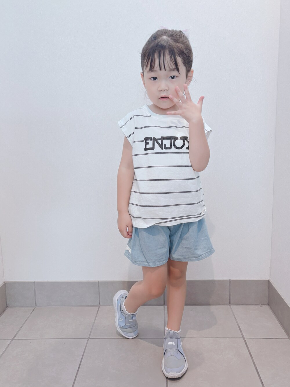 ブルー系のスニーカー、ホワイト系のトップス、ブルー系のパンツを着用したキッズの秋コーディネートの3枚目の写真