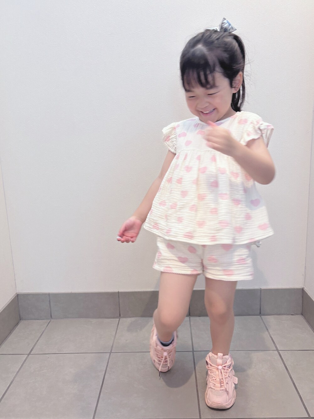 ホワイト系のトップス、ホワイト系のパンツ、ピンク系のスニーカーを着用したキッズの夏コーディネートの4枚目の写真