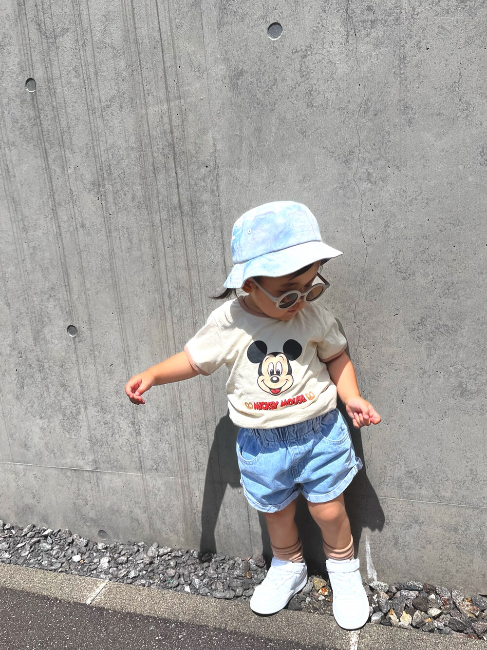 ベージュ系のTシャツ/カットソー、ブルー系のデニムパンツ、ホワイト系のスニーカーを着用したキッズの夏コーディネートの2枚目の写真