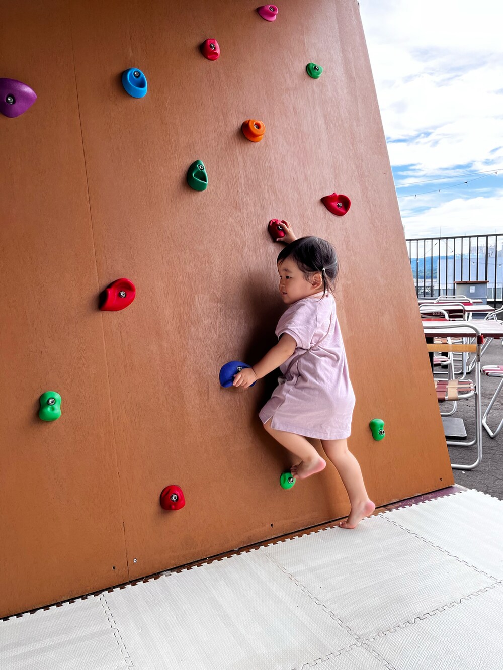 パープル系のワンピース、ベージュ系のバッグ、ベージュ系の帽子を着用したキッズの夏コーディネートの5枚目の写真
