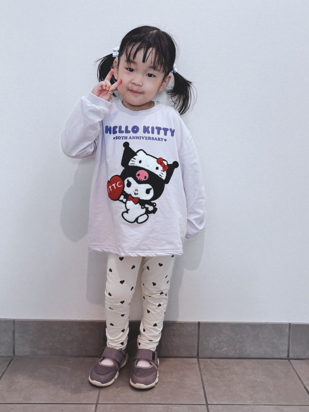 パープル系のトップス、ベージュ系のパンツ、パープル系のシューズを着用したキッズの秋コーディネートの2枚目の写真