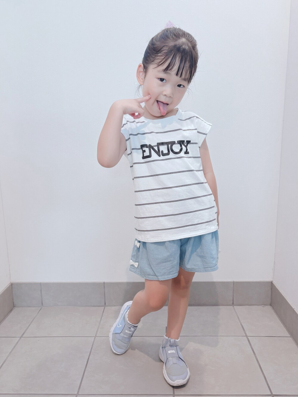 ブルー系のスニーカー、ホワイト系のトップス、ブルー系のパンツを着用したキッズの秋コーディネートの2枚目の写真