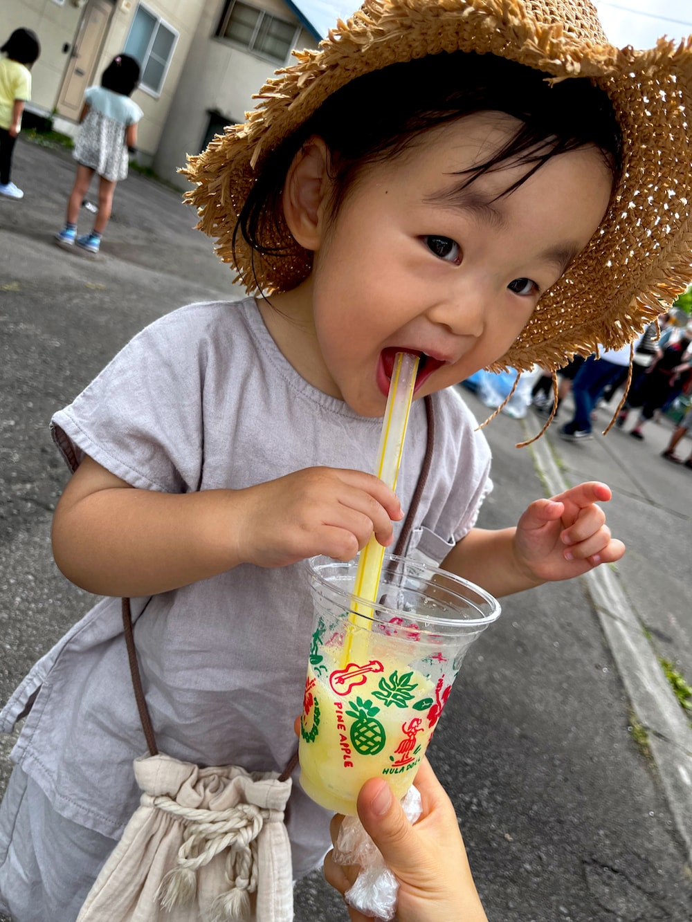 グレー系のセットアップ、ベージュ系のバッグ、ベージュ系の帽子を着用したキッズの夏コーディネートの4枚目の写真