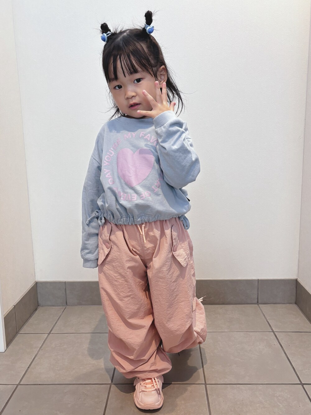 ブルー系のトップス、ピンク系のパンツ、ピンク系のスニーカーを着用したキッズの秋コーディネートの4枚目の写真