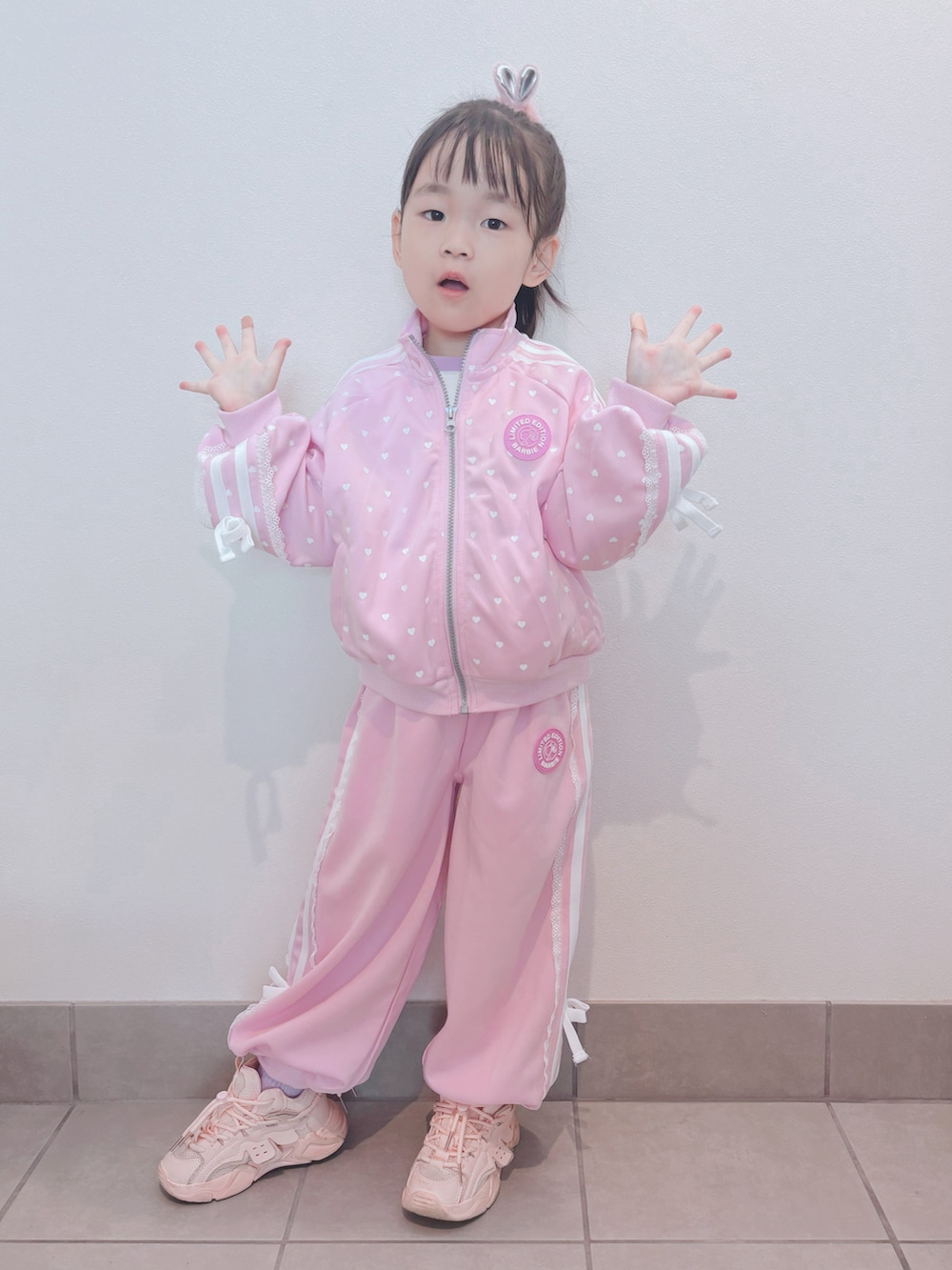 ピンク系のセットアップ、ピンク系のパンツ、ピンク系のスニーカーを着用したキッズの秋コーディネートの4枚目の写真