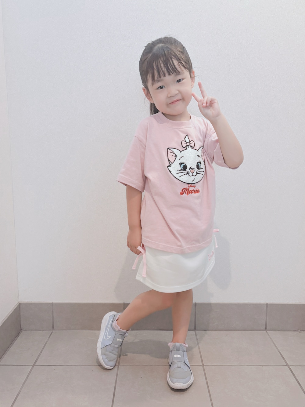 ブルー系のスニーカー、ピンク系のトップス、ホワイト系のスカートを着用したキッズの秋コーディネートの2枚目の写真