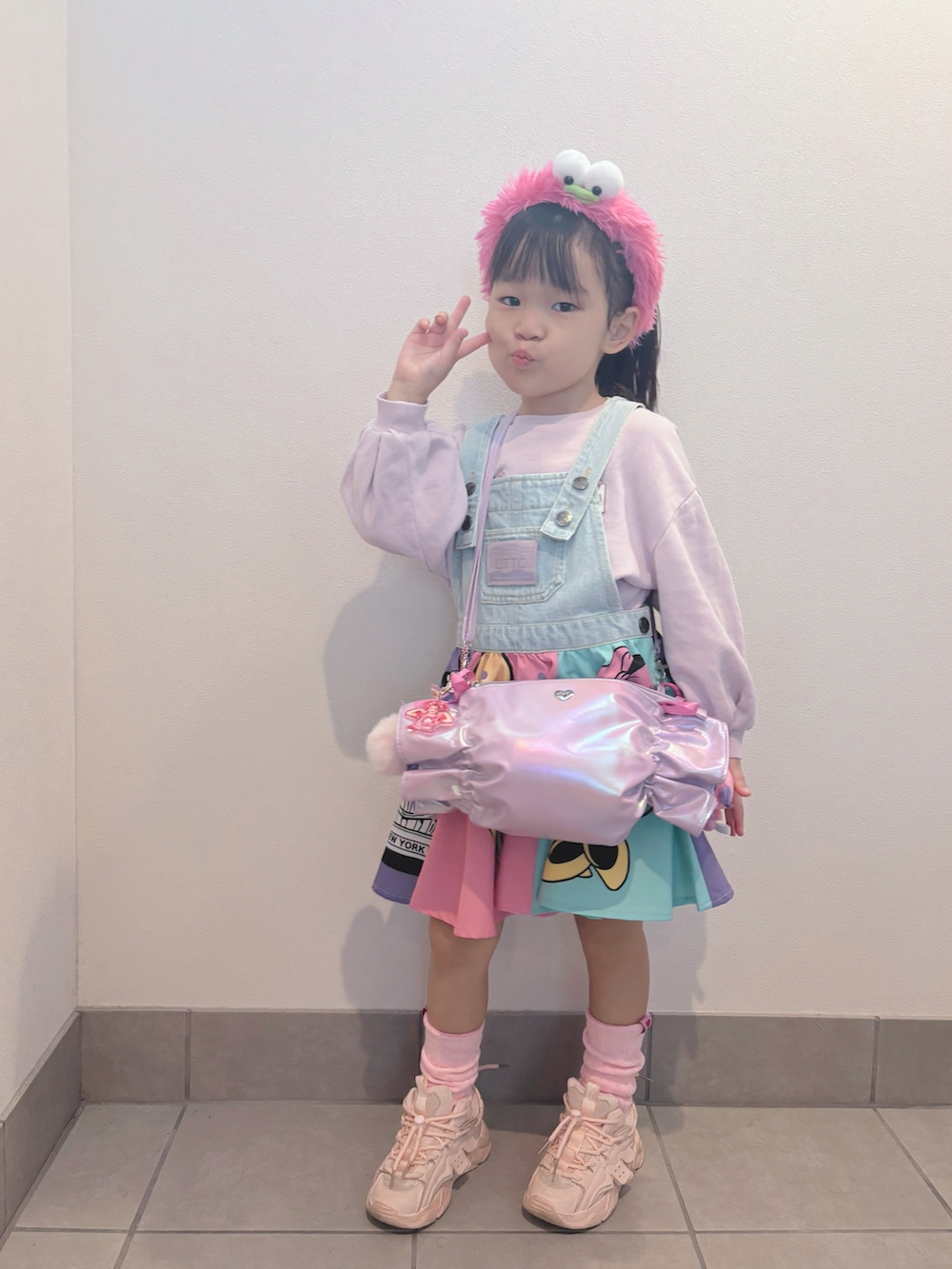 パープル系のトップス、ピンク系のワンピース/ドレス、パープル系のバッグを着用したキッズの秋コーディネートの3枚目の写真