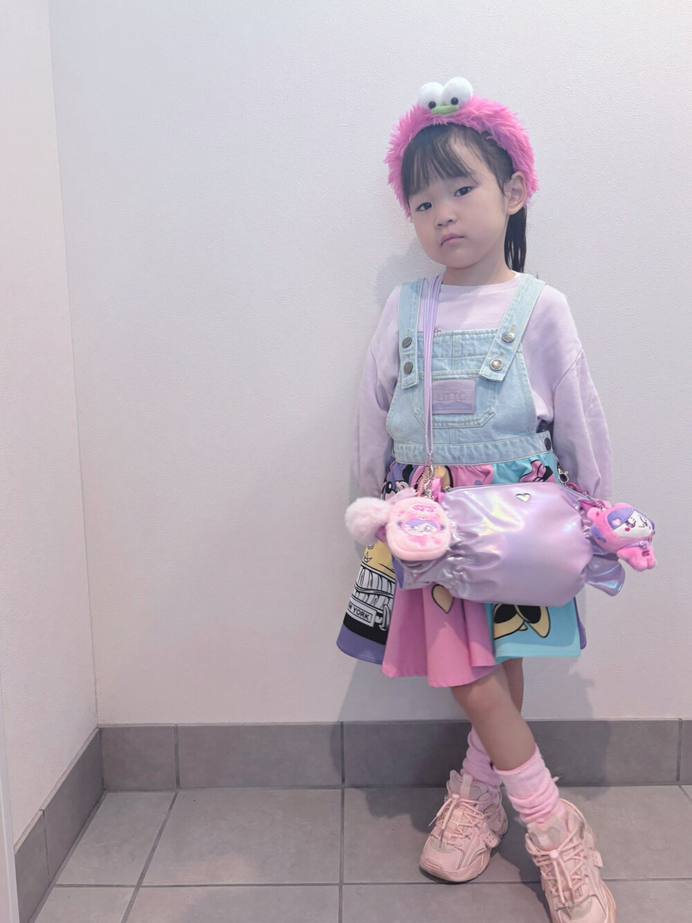 パープル系のトップス、ピンク系のワンピース/ドレス、パープル系のバッグを着用したキッズの秋コーディネートの2枚目の写真