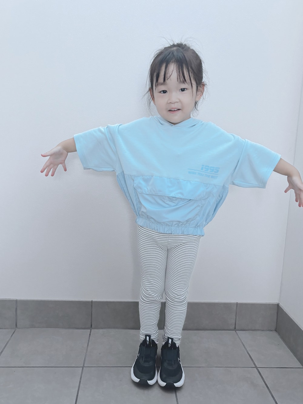 ブルー系のトップス、グレー系のパンツ、ブラック系のスニーカーを着用したキッズの秋コーディネートの2枚目の写真