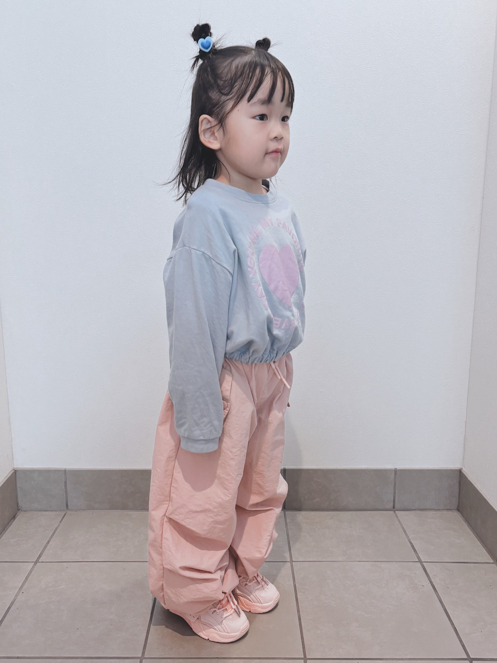 ブルー系のトップス、ピンク系のパンツ、ピンク系のスニーカーを着用したキッズの秋コーディネートの3枚目の写真