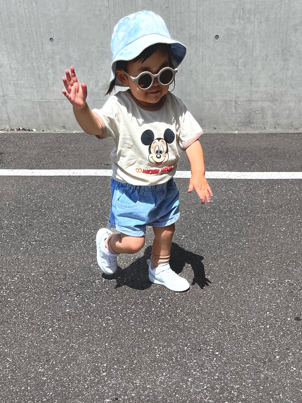 ベージュ系のTシャツ/カットソー、ブルー系のデニムパンツ、ホワイト系のスニーカーを着用したキッズの夏コーディネートの3枚目の写真