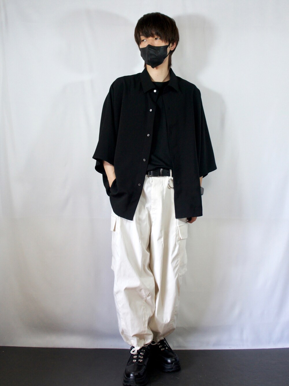 ブラック系のシャツ/ブラウス、ブラック系のタンクトップ、ホワイト系のカーゴパンツを着用したメンズの夏コーディネートの2枚目の写真