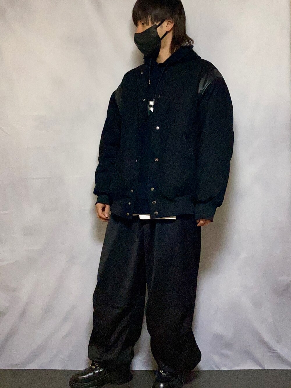 ブラック系のスタジャン、シルバー系のパーカー、ブラック系のカーゴパンツを着用したメンズの冬コーディネートの2枚目の写真