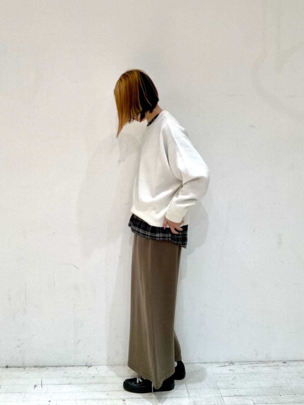 ホワイト系のニット/セーター、ブラック系のシャツ/ブラウス、ブラウン系のスカートを着用したレディースの秋コーディネートの3枚目の写真