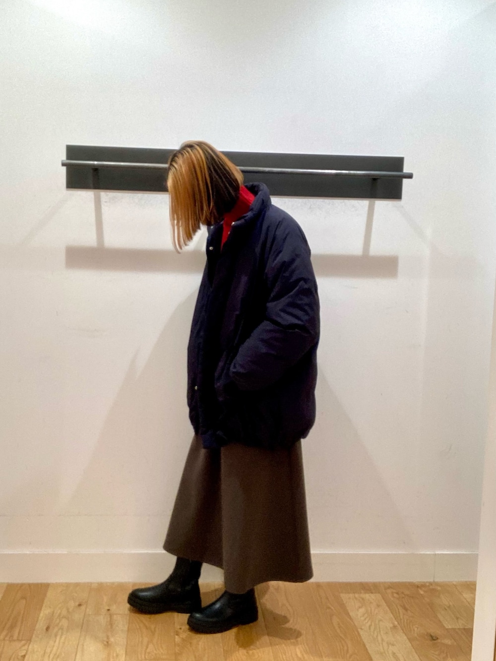 ブラック系のブルゾン、レッド系のニット/セーター、ブラウン系のスカートを着用したレディースの冬コーディネートの4枚目の写真