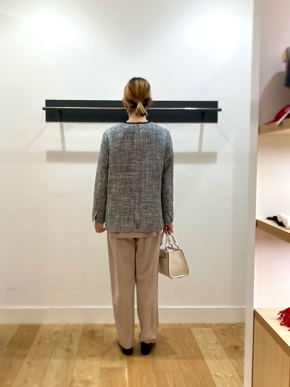 ベージュ系のセットアップ、ブラック系のスーツジャケット、ホワイト系のネックレスを着用したレディースの冬コーディネートの3枚目の写真