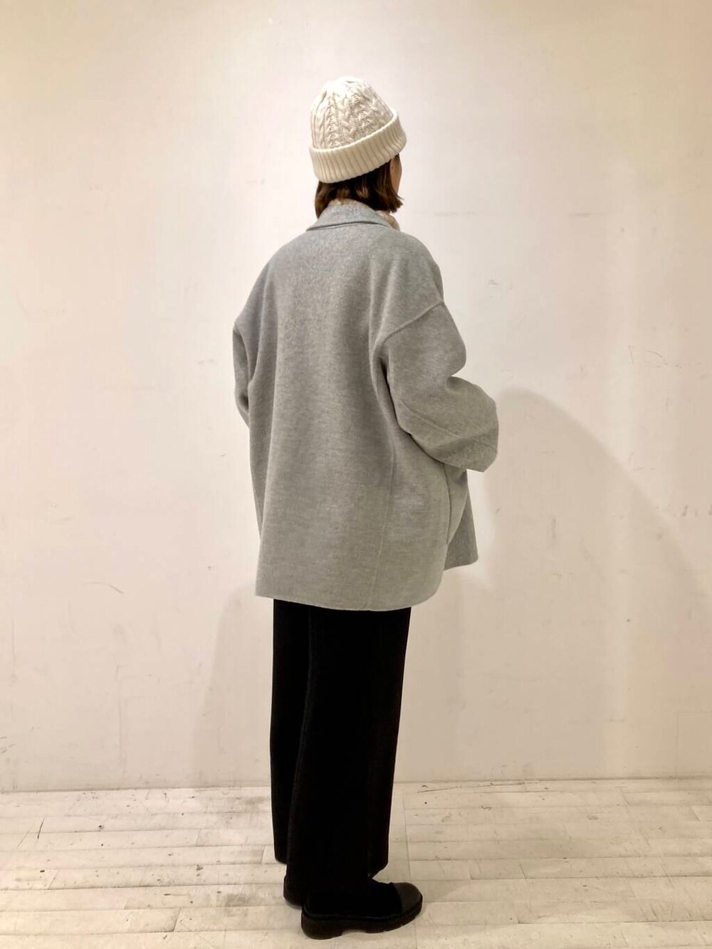 グレー系のその他アウター、ブラック系のサロペット/オーバーオール、ブラウン系のニット/セーターを着用したレディースの冬コーディネートの3枚目の写真