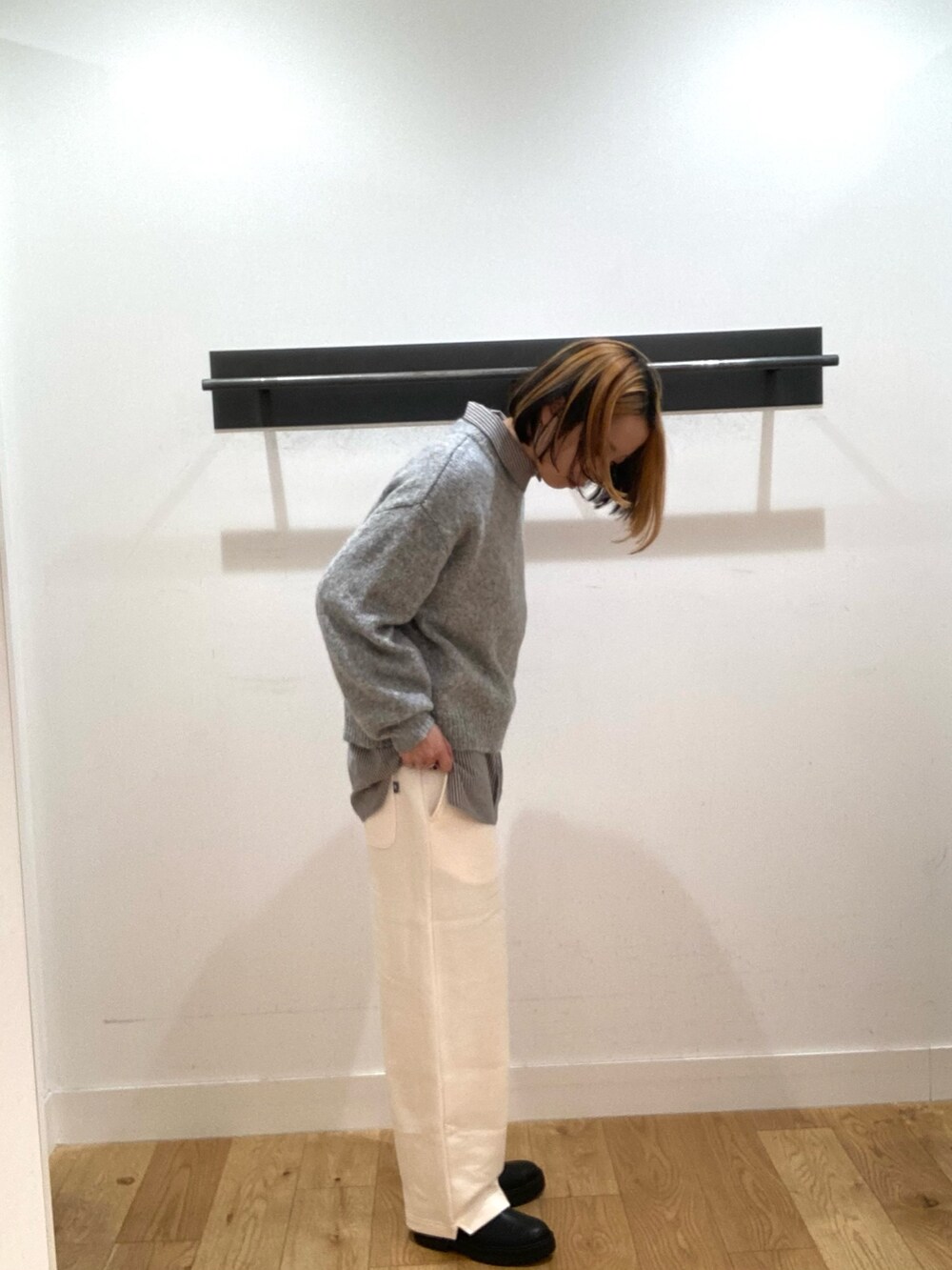 ブルー系のシャツ/ブラウス、グレー系のニット/セーター、ホワイト系のスウェットパンツを着用したレディースの冬コーディネートの2枚目の写真