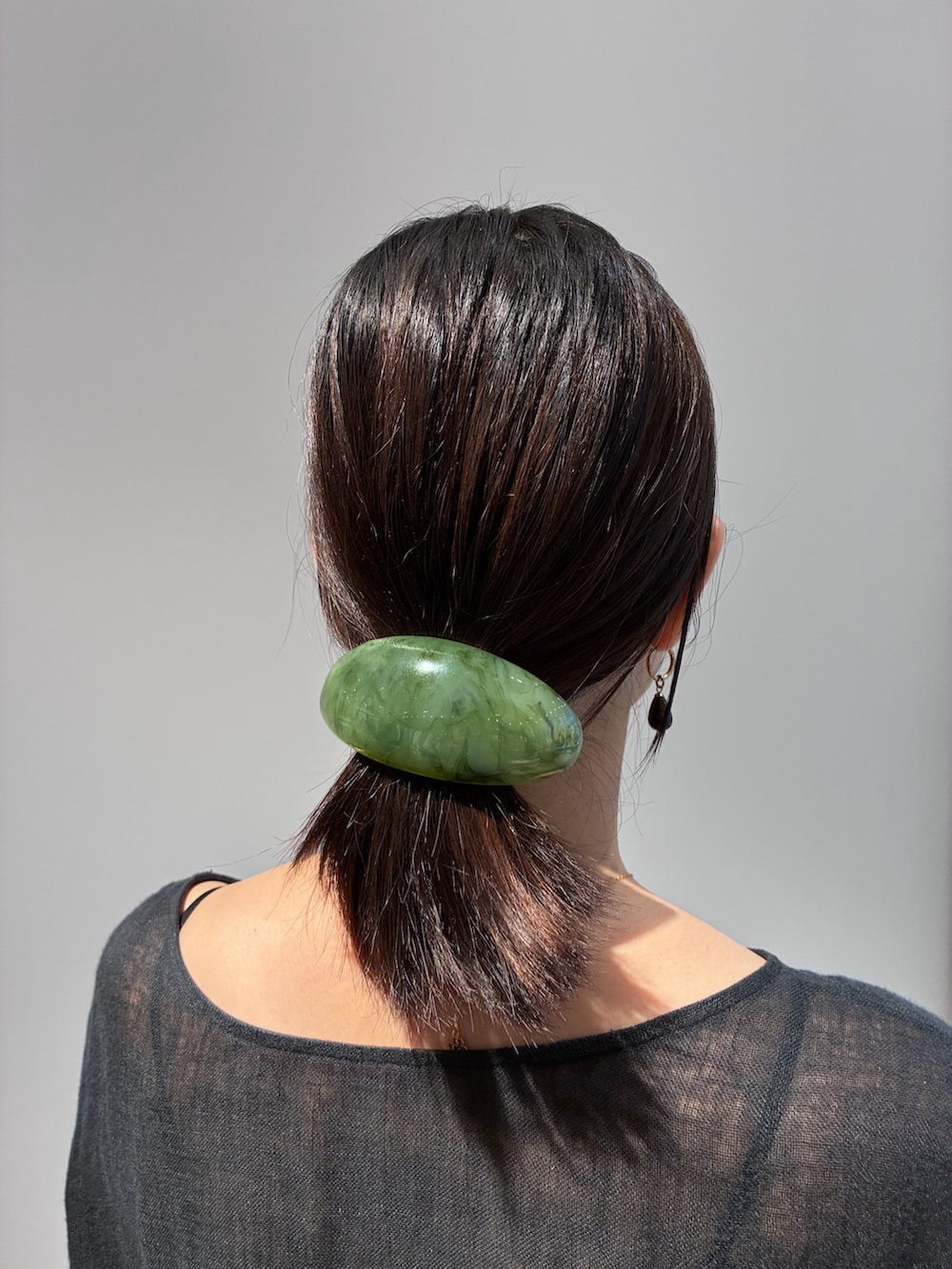 グリーン系のバレッタ/ヘアクリップ、ブラウン系のピアス(両耳用)を着用したレディースの夏コーディネートの2枚目の写真