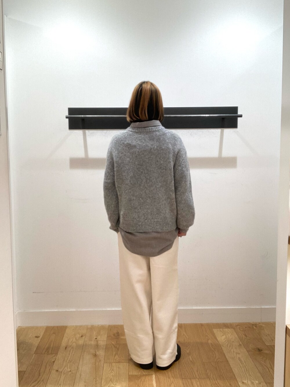 ブルー系のシャツ/ブラウス、グレー系のニット/セーター、ホワイト系のスウェットパンツを着用したレディースの冬コーディネートの3枚目の写真