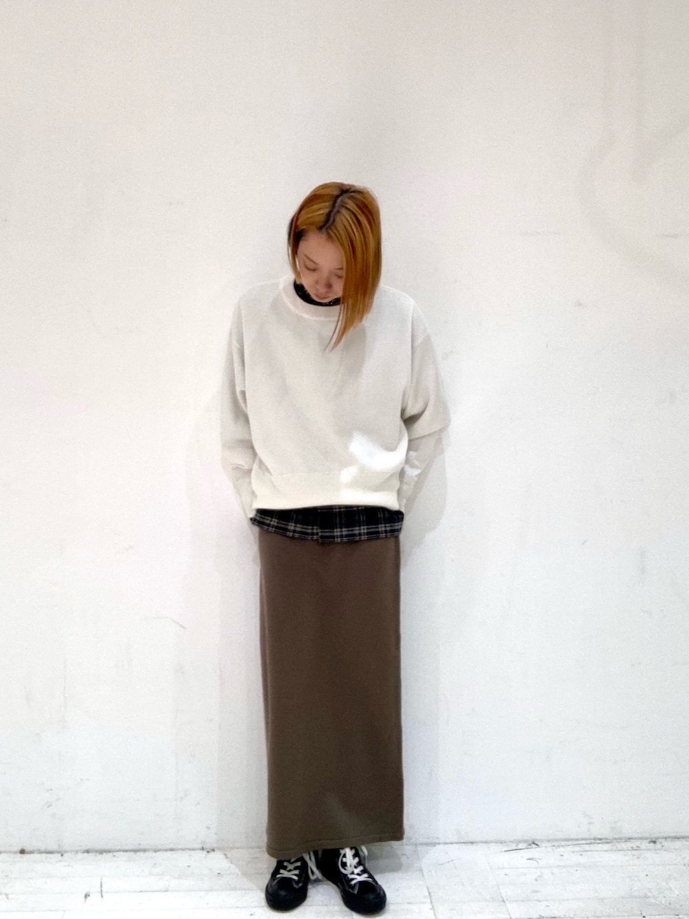 ホワイト系のニット/セーター、ブラック系のシャツ/ブラウス、ブラウン系のスカートを着用したレディースの秋コーディネートの5枚目の写真