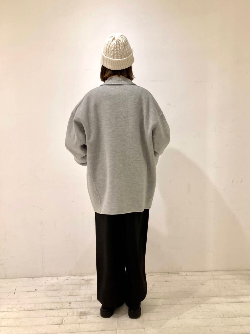 グレー系のその他アウター、ブラック系のサロペット/オーバーオール、ブラウン系のニット/セーターを着用したレディースの冬コーディネートの4枚目の写真