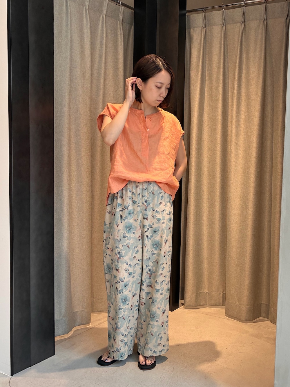 オレンジ系のシャツ/ブラウス、ブルー系のその他パンツ、ブラック系のサンダルを着用したレディースの夏コーディネートの2枚目の写真
