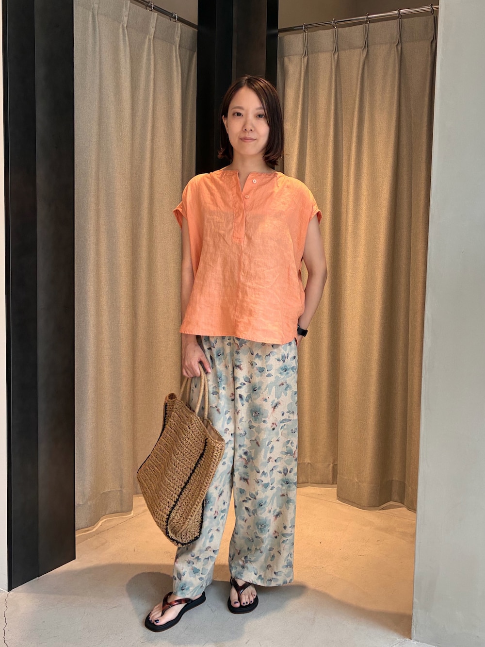オレンジ系のシャツ/ブラウス、ブルー系のその他パンツ、ブラック系のサンダルを着用したレディースの夏コーディネートの4枚目の写真