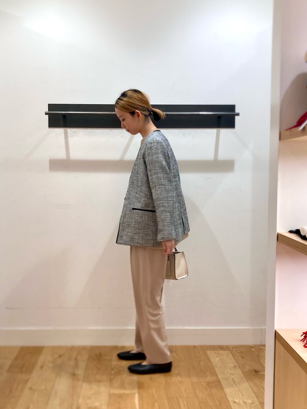 ベージュ系のセットアップ、ブラック系のスーツジャケット、ホワイト系のネックレスを着用したレディースの冬コーディネートの2枚目の写真