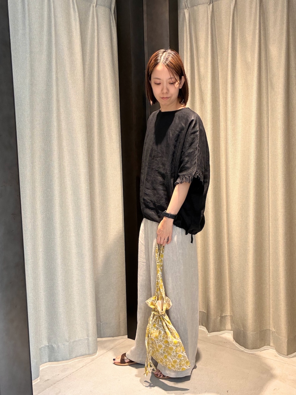 ブラック系のシャツ/ブラウス、ベージュ系のその他パンツ、イエロー系のトートバッグを着用したレディースの夏コーディネートの2枚目の写真