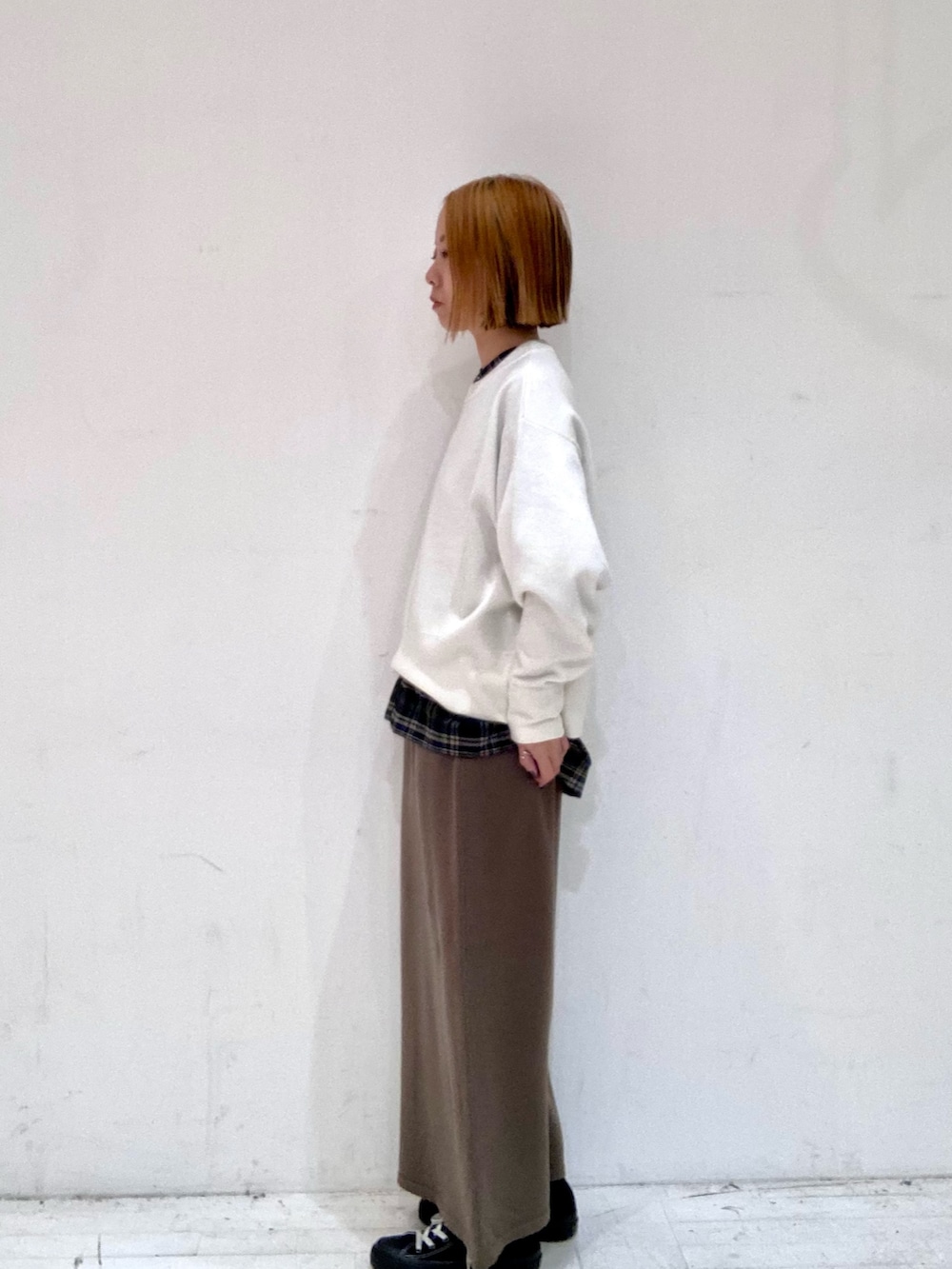 ホワイト系のニット/セーター、ブラック系のシャツ/ブラウス、ブラウン系のスカートを着用したレディースの秋コーディネートの4枚目の写真