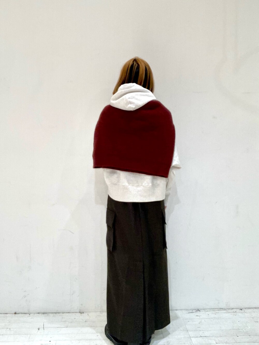 ブラウン系のスカート、ベージュ系のパーカー、レッド系のニット/セーターを着用したレディースの秋コーディネートの4枚目の写真