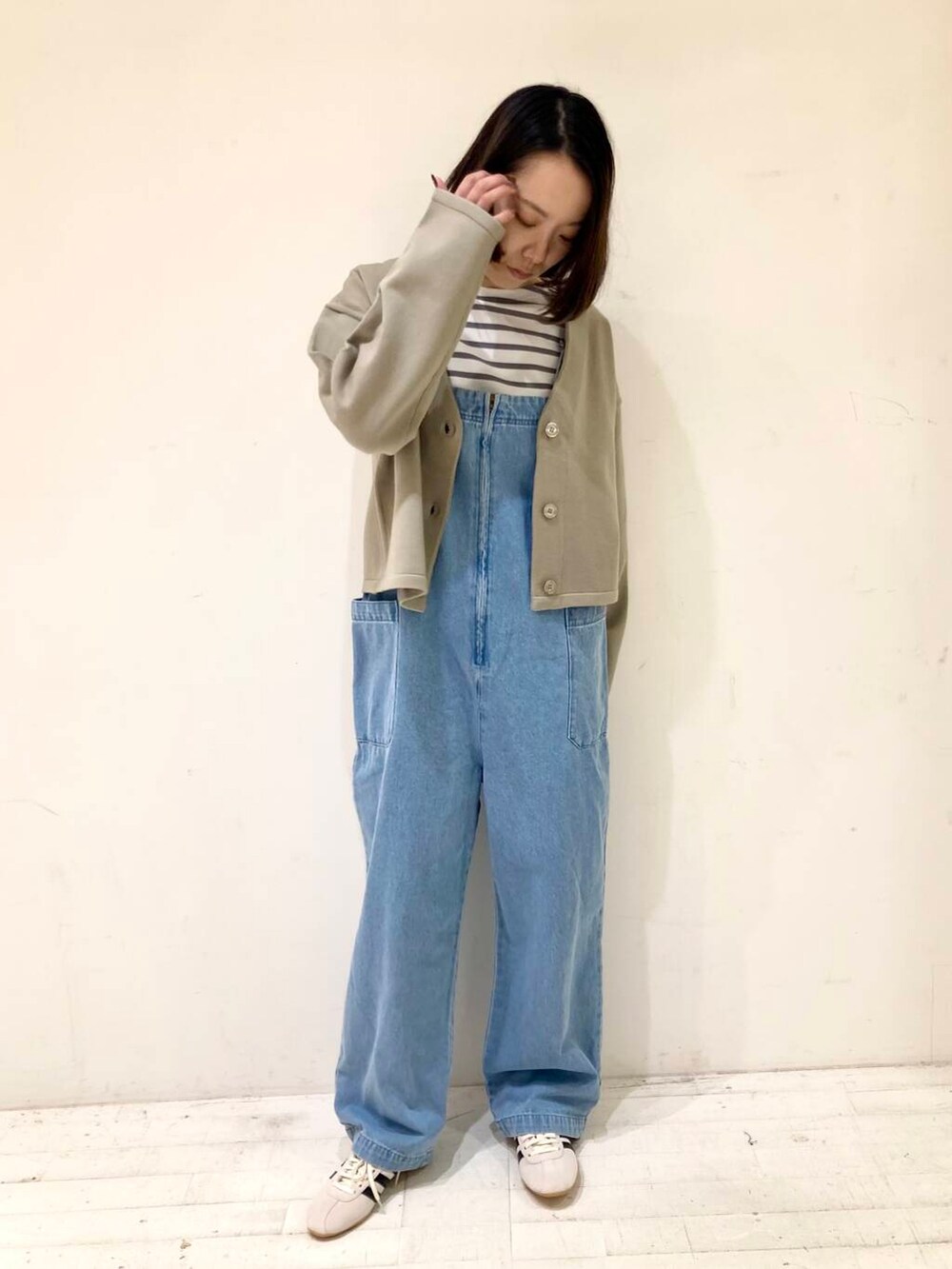 ベージュ系のカーディガン/ボレロ、グレー系のTシャツ/カットソー、ブルー系のサロペット/オーバーオールを着用したレディースの冬コーディネートの4枚目の写真