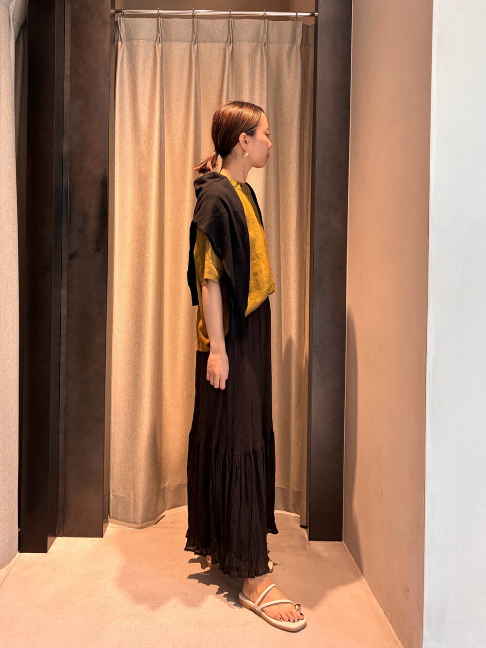 ブラウン系のスカート、イエロー系のシャツ/ブラウス、ブラック系のカーディガン/ボレロを着用したレディースの夏コーディネートの3枚目の写真