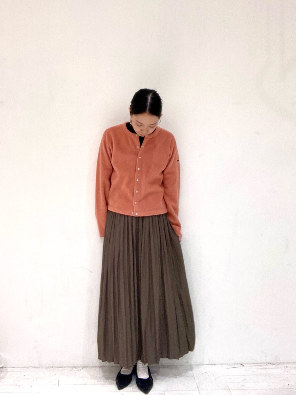 ピンク系のカーディガン/ボレロ、ブラック系のTシャツ/カットソー、ベージュ系のスカートを着用したレディースの秋コーディネートの4枚目の写真