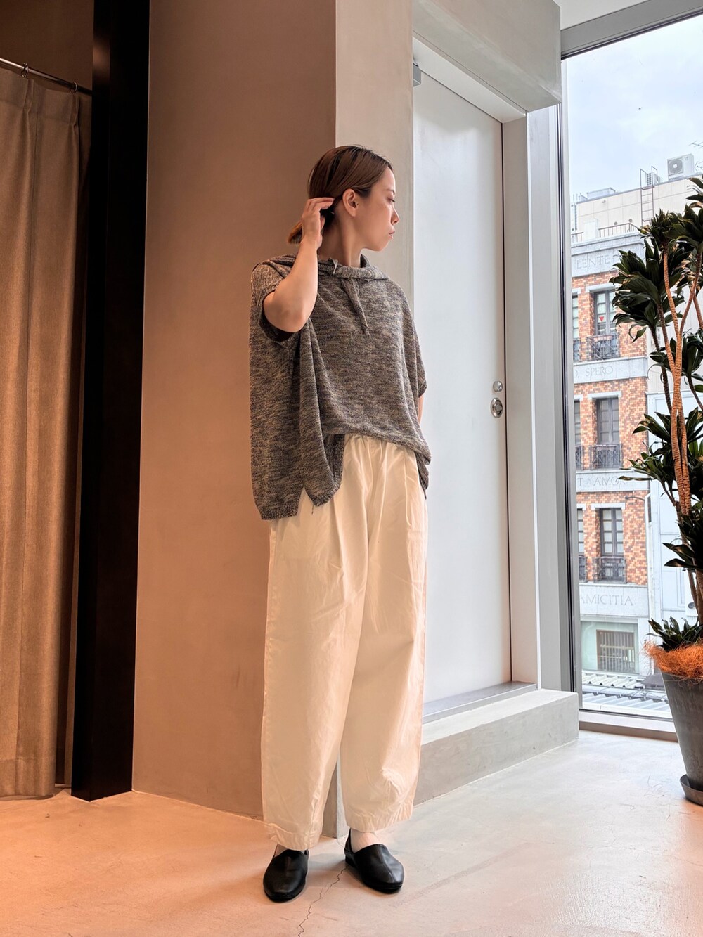 ブラック系のニット/セーター、ホワイト系のその他パンツ、ブラウン系のトートバッグを着用したレディースの夏コーディネートの3枚目の写真