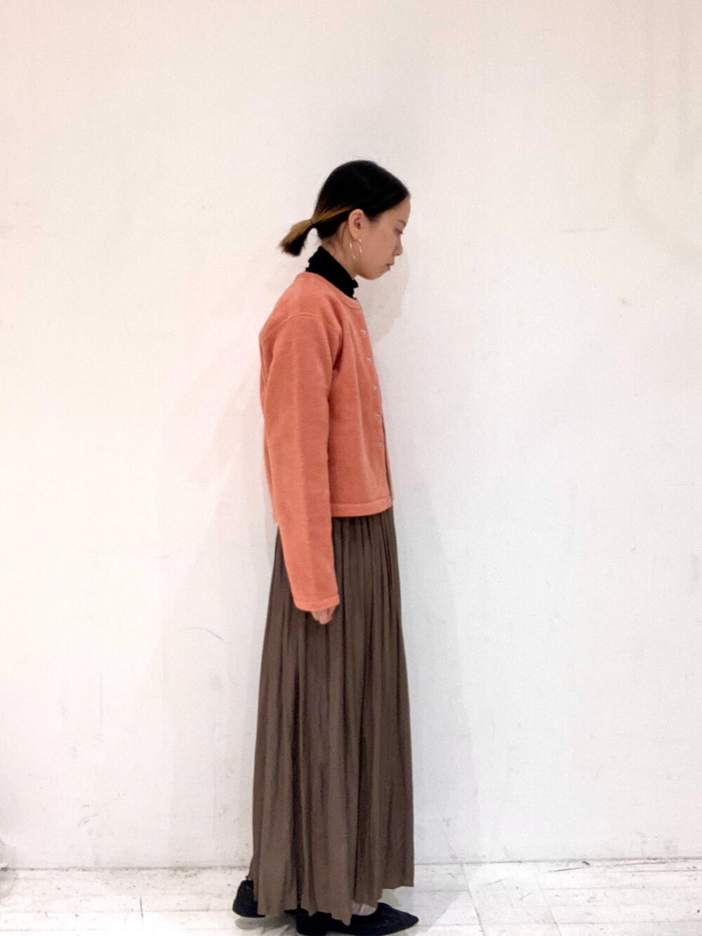 ピンク系のカーディガン/ボレロ、ブラック系のTシャツ/カットソー、ベージュ系のスカートを着用したレディースの秋コーディネートの2枚目の写真